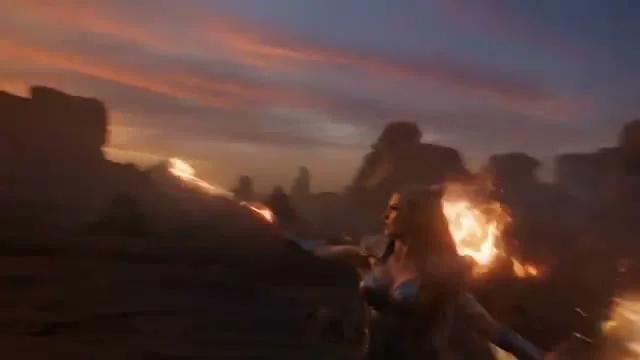 A warrior woman in armor stands in a dramatic pose amid a fiery war-torn rocky landscape at dusk, with deep purple and orange skies, flames erupting from the ground around her